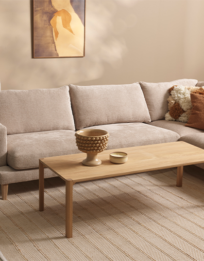 Soffbord i ljust trä vid en beige soffa