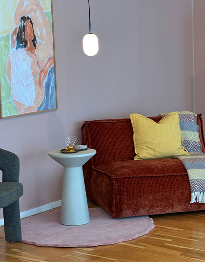 Fåtölj i rostfärgat tyg med rosa vägg