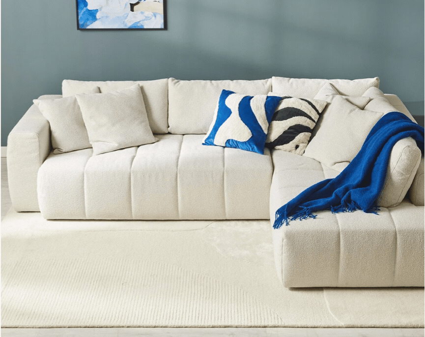 Beige hörnbäddsoffa i ett blått rum