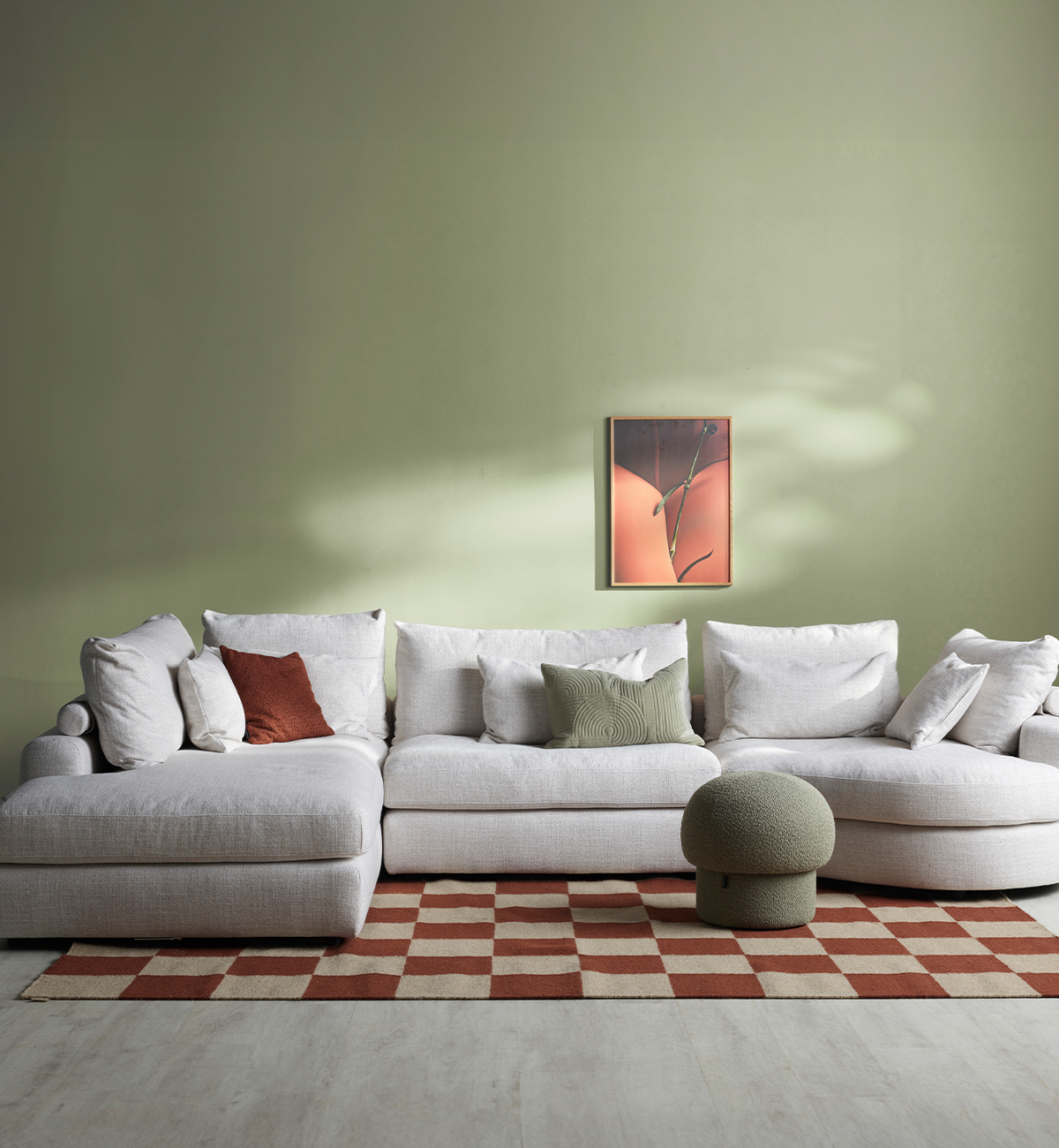 Beige soffa med öppet avslut, i ett grönt rum