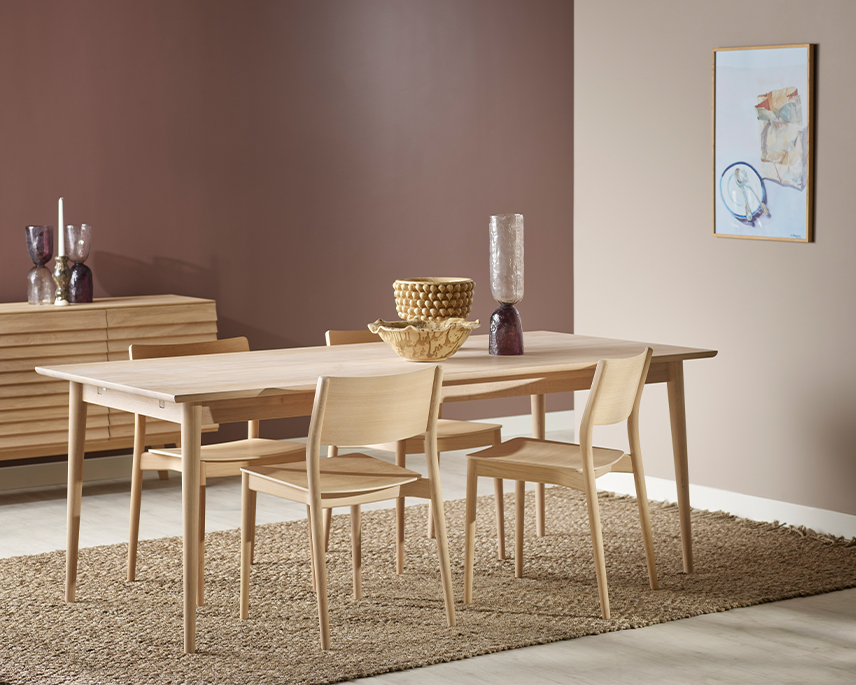 Vitoljat matbord i ek med ljusa stolar i rosa rum