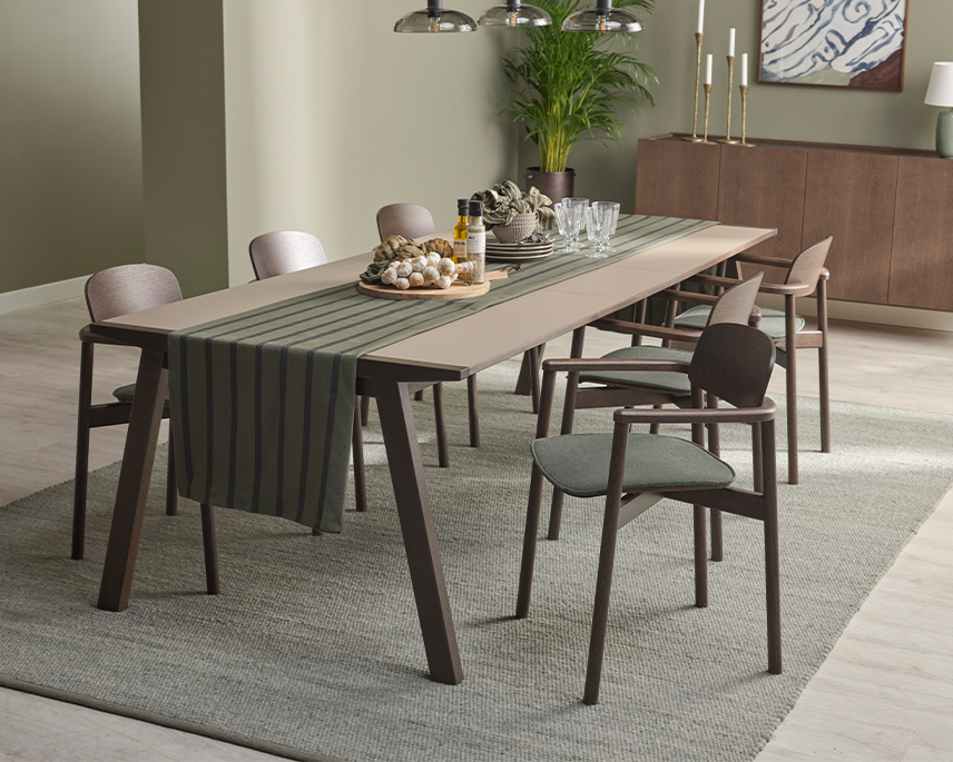 Mörkt matbord med laminat i ljusbrun och bruna stolar i grönt rum