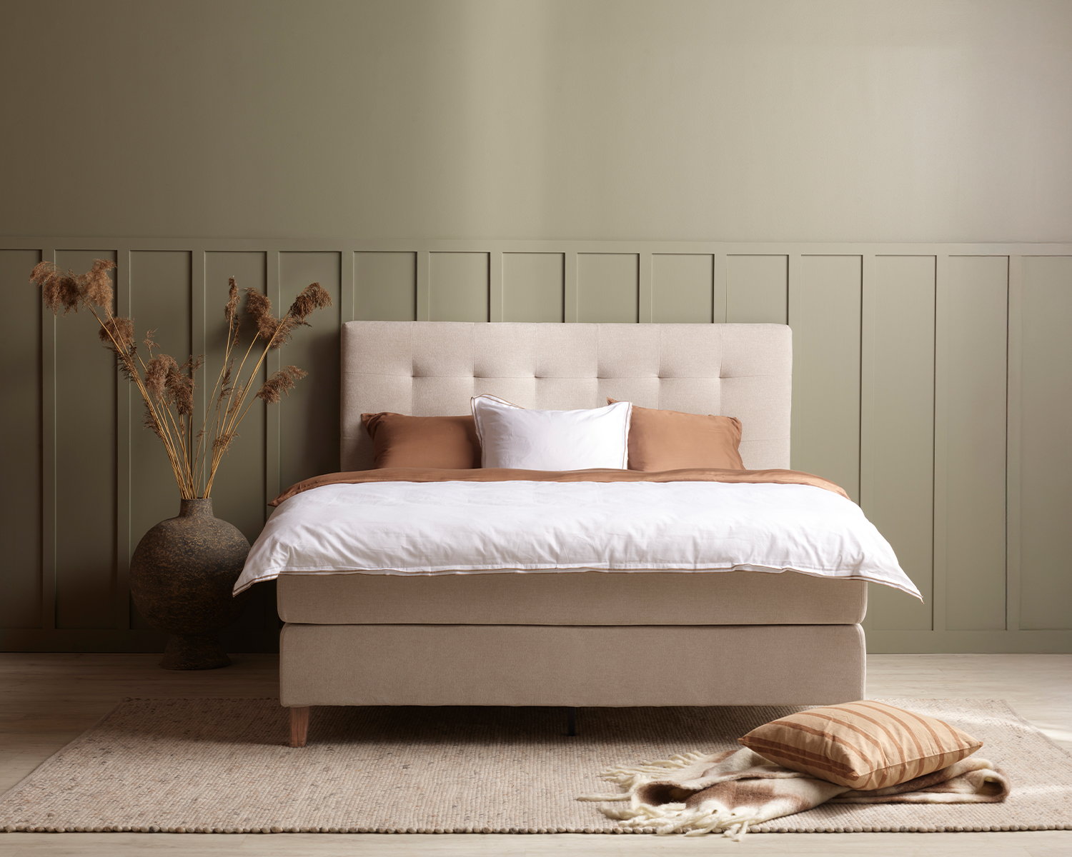 Beige kontinentalsäng i ett grönt rum