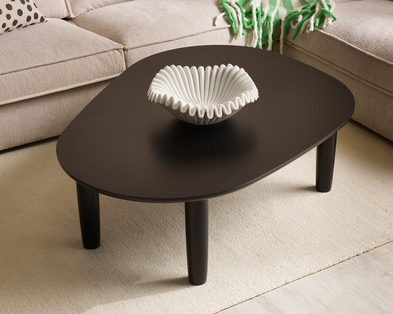 Svart soffbord vid beige soffa