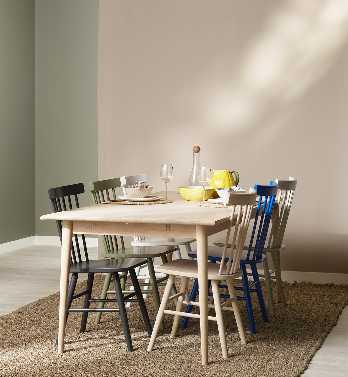 Ljust matbord i massiv ek med färgade pinnstolar