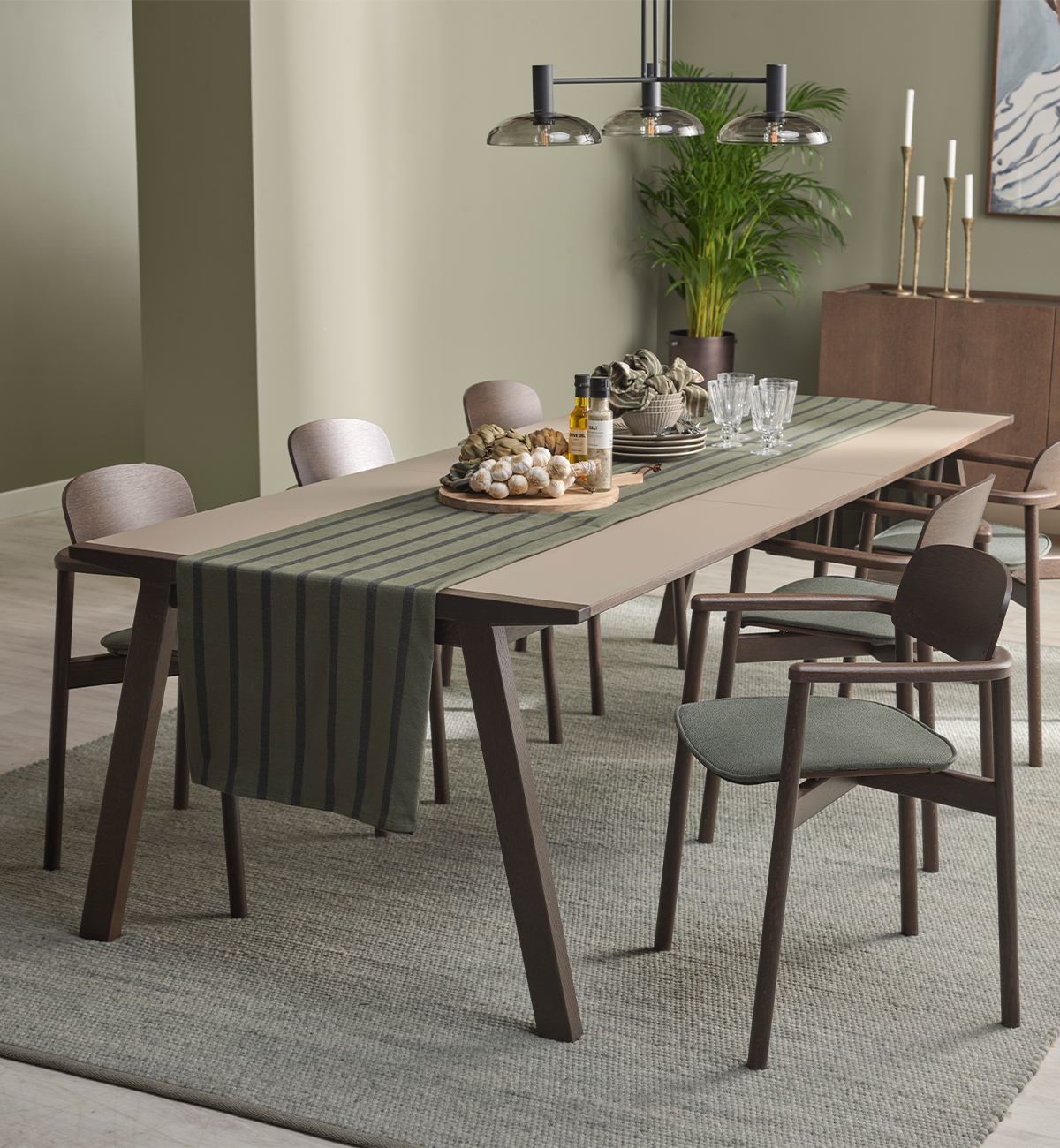 Mörkt matbord med laminat i ljusbrun och bruna stolar i grönt rum