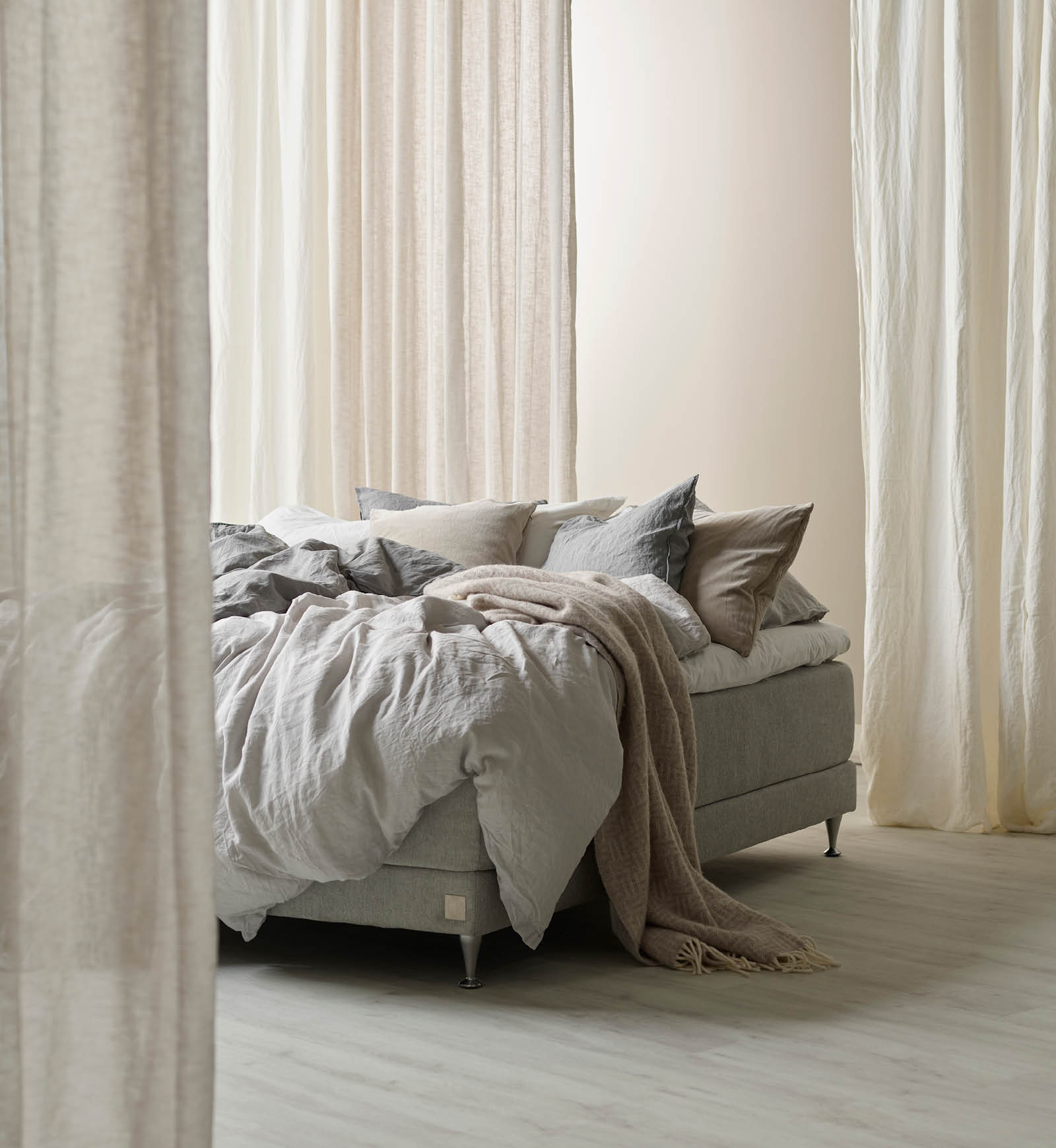 Beige säng med täcken och textil