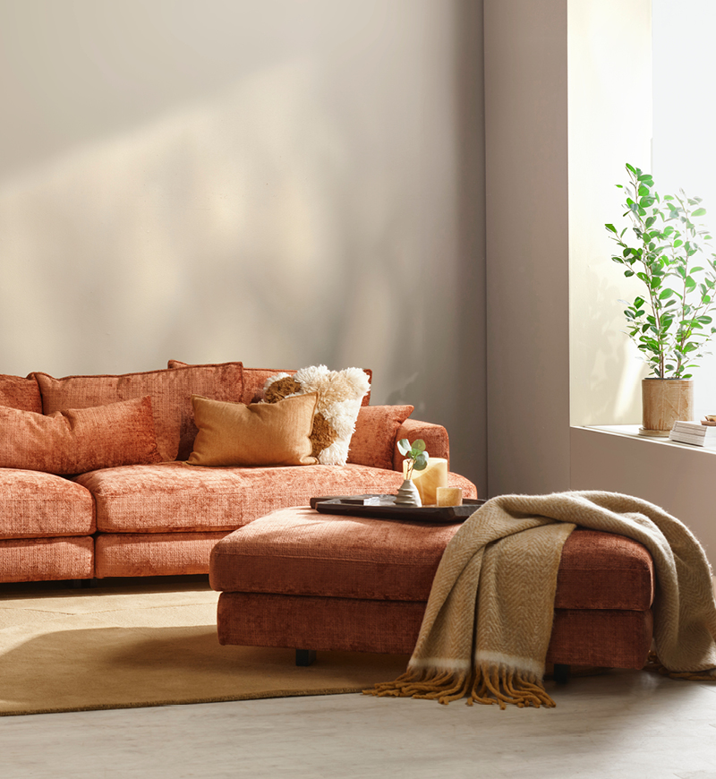 Rostfärgad soffa med gula kuddar