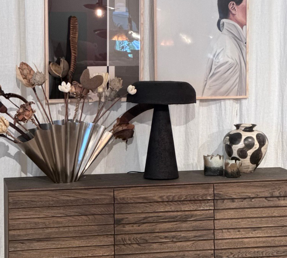 Vas och lampa på ett brunt sideboard