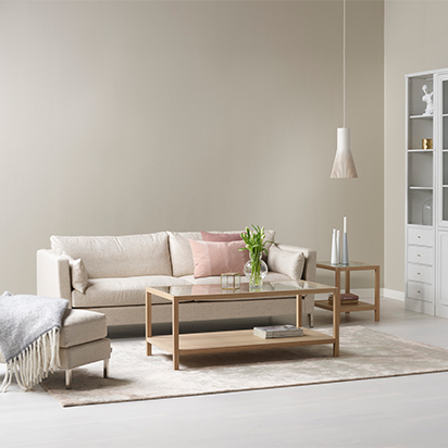Beige soffa med soffbord och pall