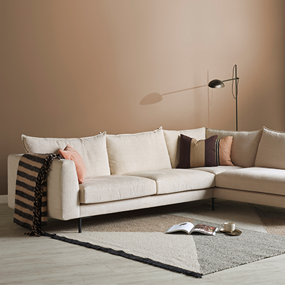 Beige soffa med bruna och rosa kuddar