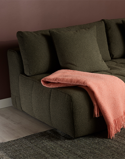 Grön bäddsoffa med rosa pläd