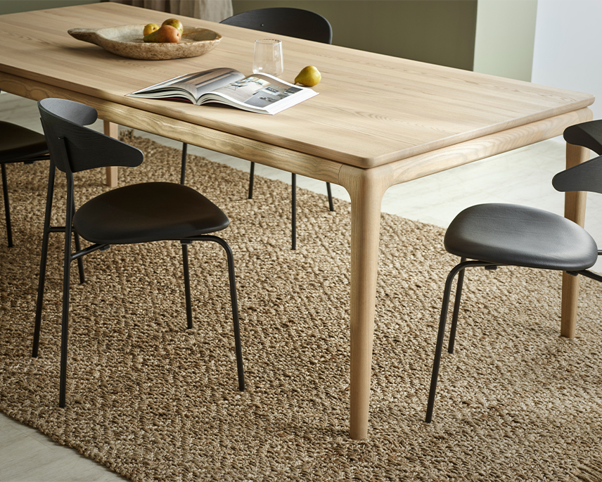 Ljust matbord med svarta stolar