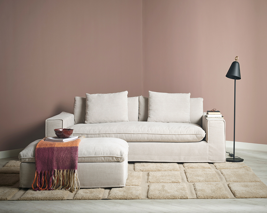 Beige soffa med pall i rosa rum