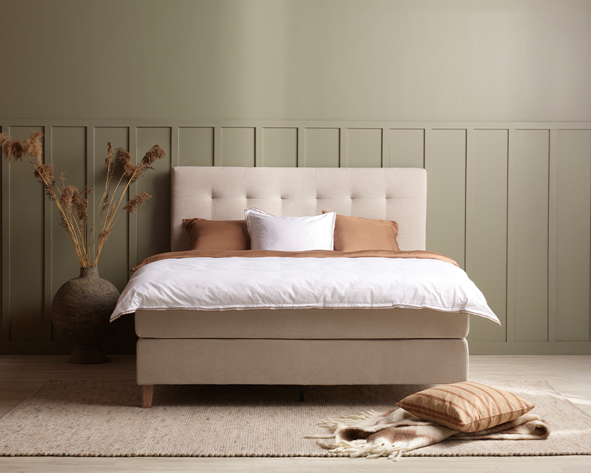Beige kontinentalsäng i grönt rum 