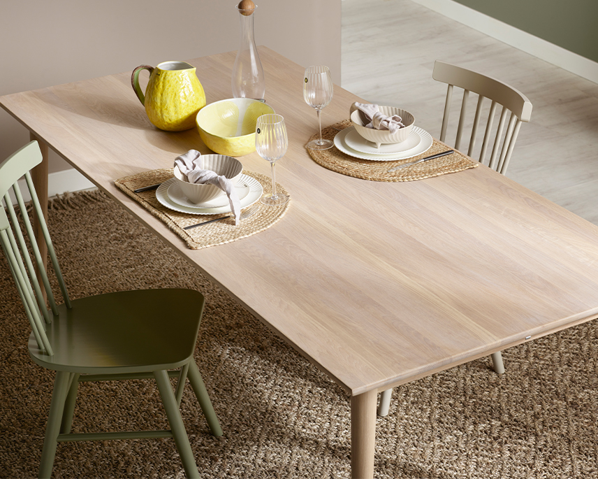 Ljust mabord med gröna pinnstolar