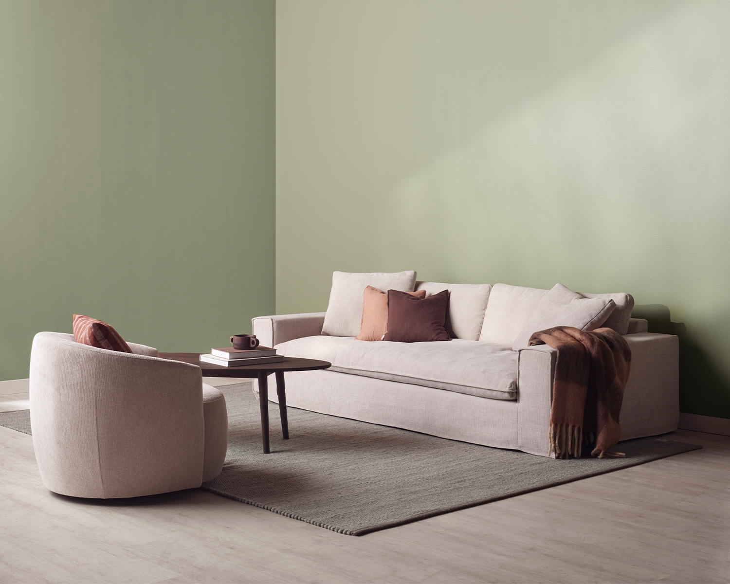 Beige soffa och fåtölj i grönt rum