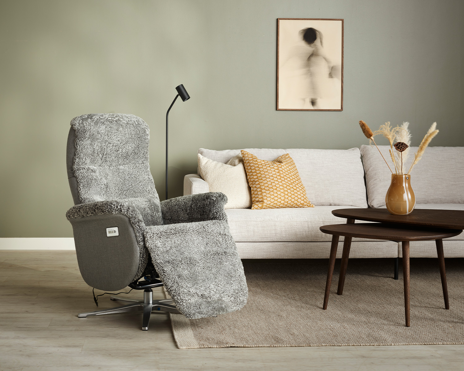 grå fårskinnsfåtölj med inbyggt fotstöd