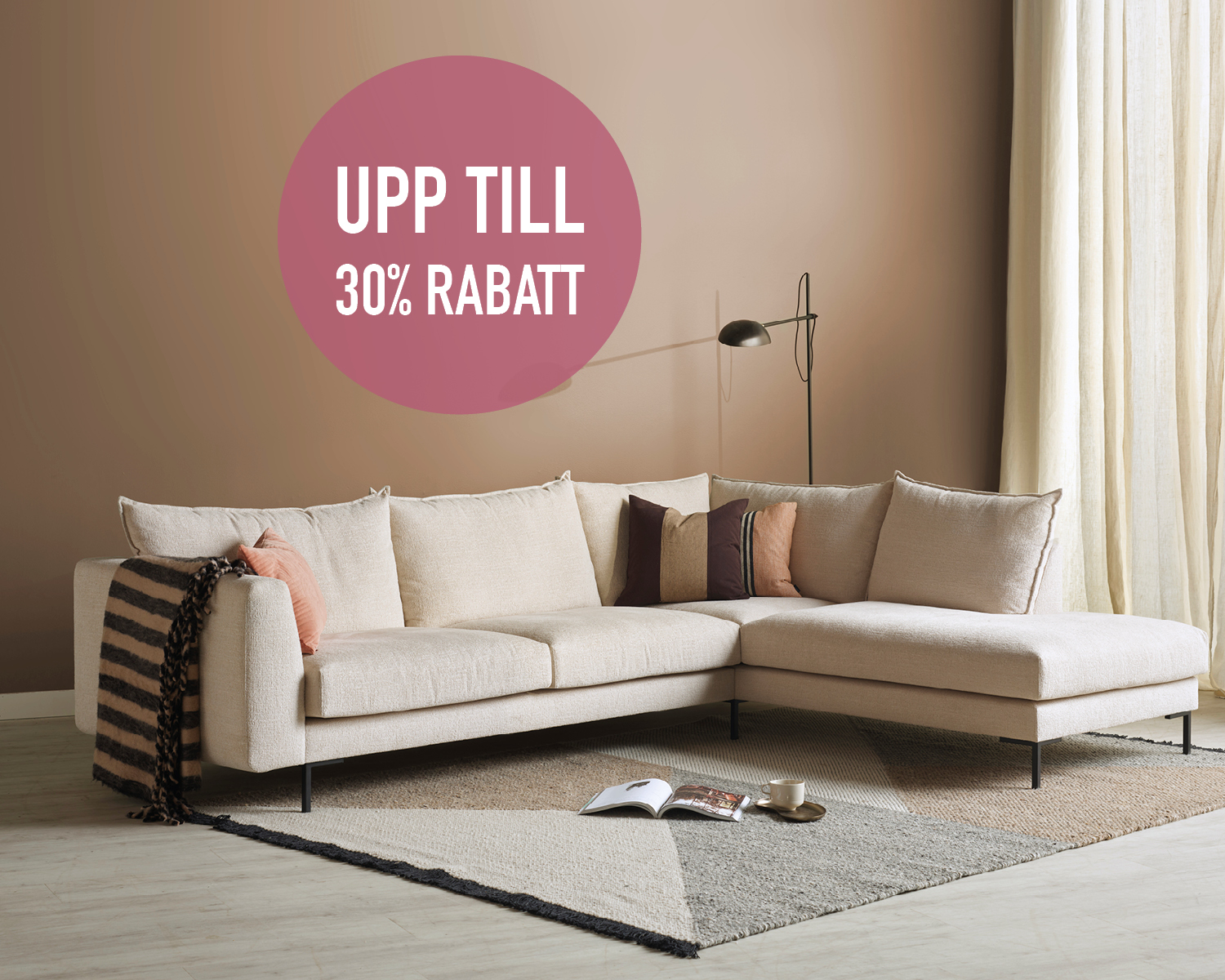 Beige soffa med rosa kuddar i ett brunt rum
