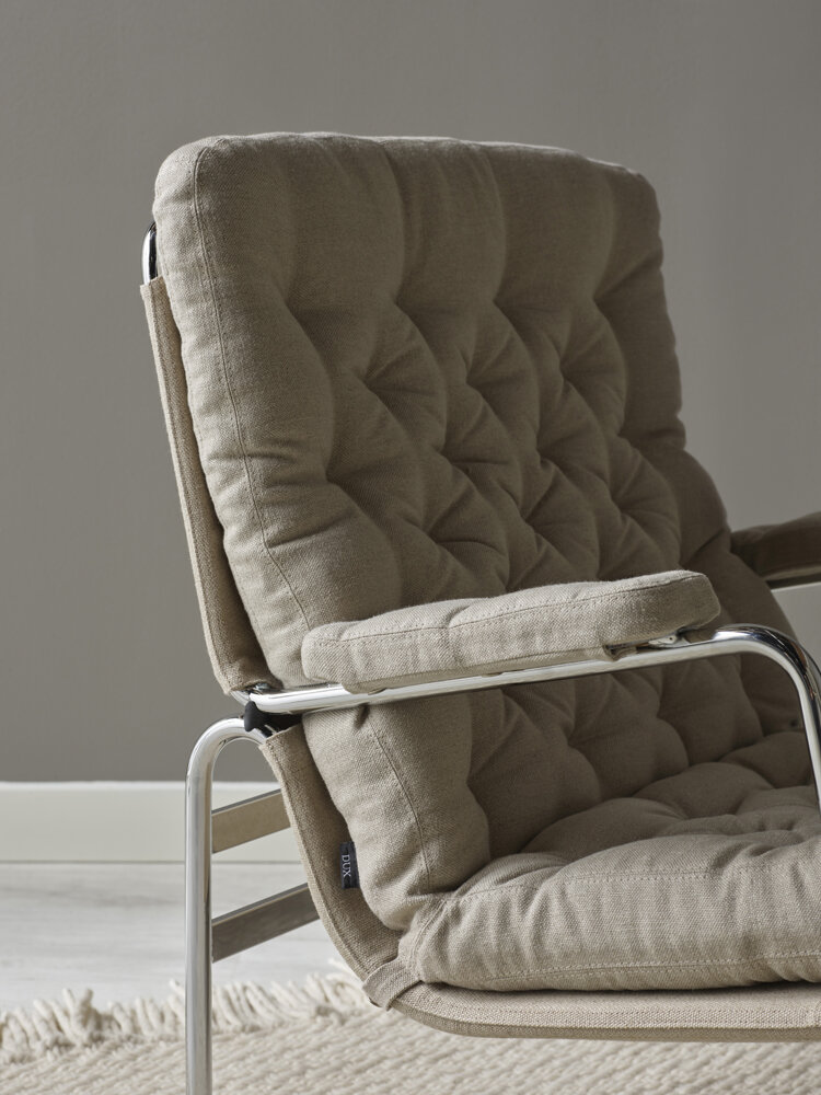 Karin 73, en ikonisk designklassiker av Bruno Mathsson för DUX. Med fåtöljens smidiga hjul, elastiska väven i ramen och rejält stoppade plymåer.